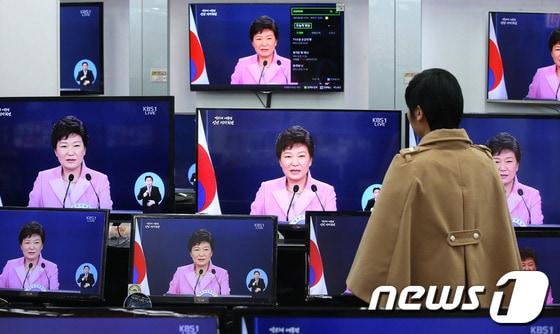 본문 이미지 - 박근혜 대통령의 취임후 첫 신년 기자회견이 열린 6일 오전 서울 용산 전자랜드에서 상인들이 박 대통령의 기자회견 모습을 TV를 통해 시청하고 있다. © News1 이광호 기자