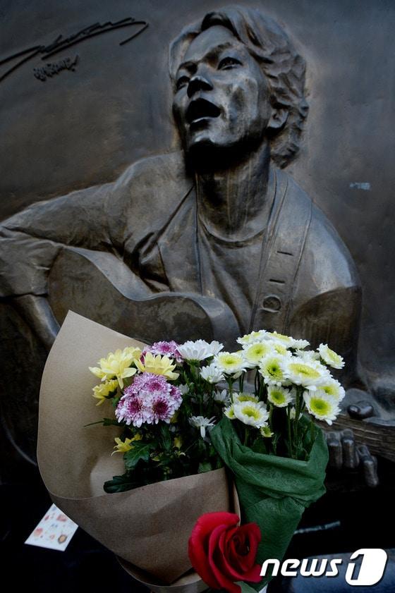 본문 이미지 - 가수 故 김광석 18주기를 맞은 6일 오후 서울 대학로 학전블루소극장 故 김광석씨 노래비 고인을 추모하는 들국화 꽃이 놓여있다. 학전블루 소극장은 고 김광석이 생전 1000회의 콘서트를 통해 많은 사람들을 만난 곳이다. 1월 22일은 김광석 탄생 50주년이 되는 날이다. 2014.1.6/뉴스1