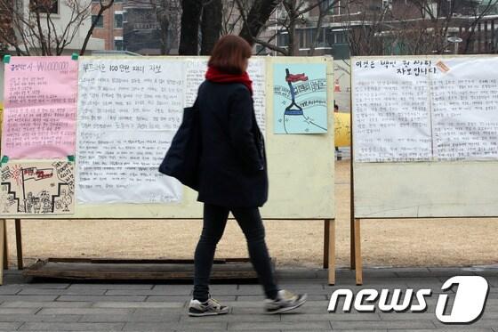 본문 이미지 - 7일 오후 서울 동작구 흑석동 중앙대학교 중앙마루에서 근무환경 개선과 용역업체 교체를 주장하며 농성 중인 이 학교 청소노동자들을 지지하는 대자보 게시판 앞으로 한 학생이 지나고 있다./뉴스1 © News1 한재호 기자