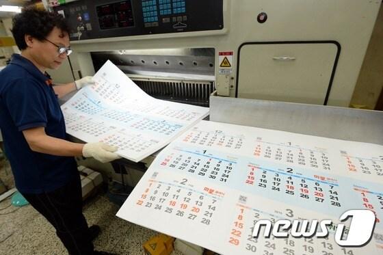 본문 이미지 - 서울 중구 필동의 한 인쇄업체 창일제책사에서 직원이 2015년 을미년(乙未年) 달력을 제작하고 있다. 2014.10.1 ⓒ News1 정회성 기자