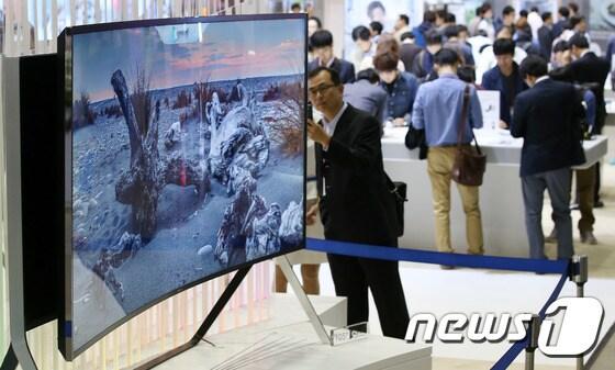 본문 이미지 - '세계적인 창조IT 종합전시회' 2014 한국전자산업대전(KES 2014) 전시장을 찾은 관람객들이 삼성전자가 국내 첫 공개한 곡면과 평면을 넘나드는 105형 벤더블 UHD(초고해상도) TV를 살펴보고 있다.2014.10.14/뉴스1 ⓒ News1 오대일 기자