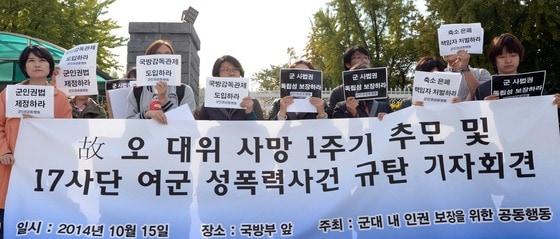 본문 이미지 - 군인권센터·민변·참여연대 등으로 구성된 군내내 인권 보장을 위한 공동행동 활동가들이 2014년 10월 15일 오전 서울 용산구 한강로동 국방부 서문 앞에서 故 오 대위 사망 1주기 추모 및 17사단 여군 성폭력사건 규탄 기자회견을 열고 있다. 故 오 대위는 직속상관의 지속적인 성관계 요구와 성추행, 폭언을 견디지 못하겠다는 내용의 유서를 남기고 지난해 10월 16일 부대 근처 자신의 차량 안에서 숨진 채 발견됐다. 육군 2군단 보통군사법원은 오대위를 죽음으로 몰고간 가해자 A소령에 대해 징역 2년에 집행유예 4년을 선고해 솜방망이 처벌 논란을 야기한 바 있다. ⓒ News1 