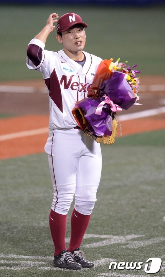 본문 이미지 - 17일 오후 서울 목동야구장에서 열린 2014 한국야쿠르트 세븐 프로야구 넥센히어로즈와 SK와이번스의 경기에서 넥센 1회말 공수교대 때 서건창이 200안타 기념 꽃다발을 들고 팬들의 환호에 답하고 있다. 서건창은 16일까지 127경기에서 199안타를 기록, 시즌 최종전에서 프로야구 최초로 "꿈의 200안타"에 도전한다. 1994년 이종범이 세운 한 시즌 최다 안타 기록(196개)은 이미 뛰어넘었다. 또 서건창은 134득점으로 1999년 이승엽이 세운 한 시즌 최다 득점(128개)를 넘어 신기록을 쓰고 있다. 프로야구 두 레전드의 10여년, 20여년 묵은 기록을 넘어선 것이다. 서건창은 타격 1위까지 3관왕을 노리고 있다. 2014.10.17/뉴스1 ⓒ News1 이동원 기자