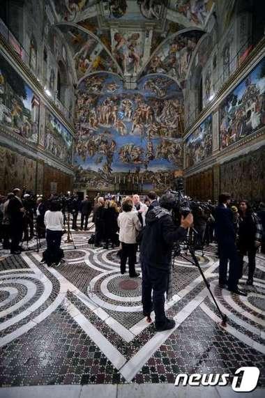 본문 이미지 - 바티칸을 출입하는 언론인들이 29일(현지시간) 로마 시스티나성당 내부에 새로 장식된 LED(발광다이오드) 조명시설을 둘러보고 있다. @AFP=News1