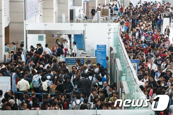 본문 이미지 - 지난 5일 인천국제공항 출국장이 중국 국경절 연휴를 맞아 한국을 찾았던 중국인 관광객(요우커·遊客)들과 여행객, 인천아시안게임을 마치고 귀국하는 선수단 등으로 북새통을 이루고 있다. 2014.10.5/뉴스1 ⓒ News1 유승관 기자