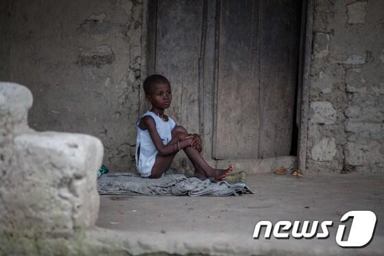 본문 이미지 - 6일(현지시간) 에볼라 바이러스 감염이 의심되는 한 시에라리온 소녀가 병원 한쪽 구석에 격리된 채 앉아 있다.ⓒ AFP=뉴스1
