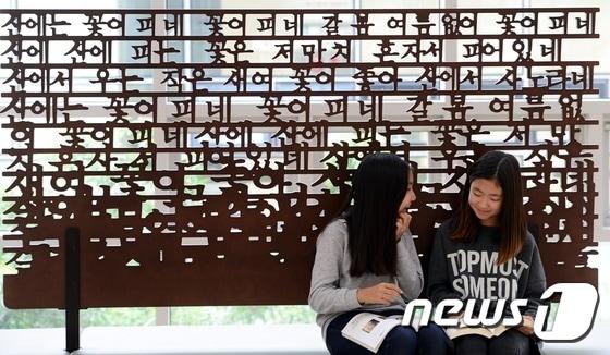 본문 이미지 - 한글날을 하루 앞둔 8일 오후 서울 용산구 국립한글박물관에서 학생들이 한글 모양의 조형물 앞에서 책을 읽고 있다. 2014.10.8/뉴스1 ⓒ News1 양동욱 기자