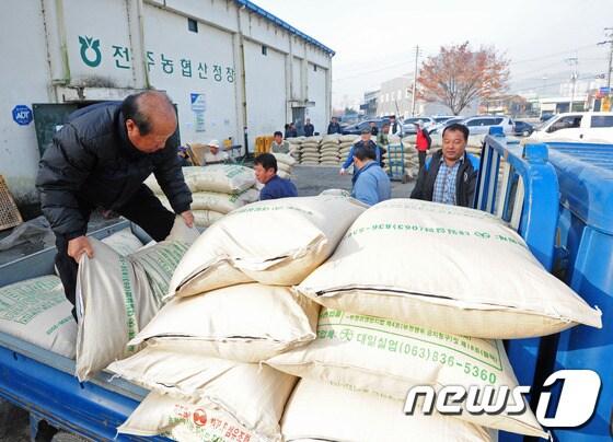 본문 이미지 - 전주시 공공비축미곡 매입이 실시되자 전북 전주시 덕진동 산정창고에서 한 농민이 쌀포대를 내리고 있다. ⓒ News1 김대웅 기자