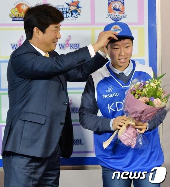 본문 이미지 - 11일 오전 서울 여의도 63컨벤션센터에서 열린 2014 여자프로농구(WKBL) 신인드래프트에서 동주여고 안혜지가 1라운드 1순위로 KDB생명에 지명된 후 유니폼을 입고 있다. 이날 드래프트는 고교 졸업 예정 선수 13명, 대학 선수 9명 총 22명의 신청자를 대상으로 실시됐다. 2014.11.11/뉴스1 ⓒ News1 손형주 기자