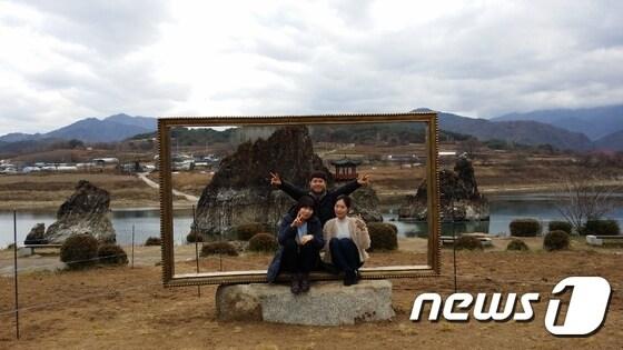 본문 이미지 - 단양군의 대표적 관광지인 도담삼봉에 대형 액자 조형물이 설치 관광객들이 기념촬영을 하고 있다.ⓒ News1