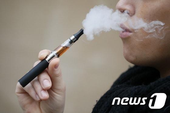 본문 이미지 - 액상 니코틴이 든 전자담배를 피우는 흡연자. ⓒ AFP=뉴스1