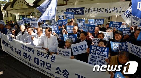 본문 이미지 - 아시아태평양전쟁희생자한국유족회 소속 회원들이 지난해 11월 서울 세종로 정부서울청사 후문에서 열린 대일청구권 자금 환수 대규모 소송제기 기자회견에서 구호를 외치고 있다. 2014.11.3/뉴스1 ⓒ News1 허경 기자