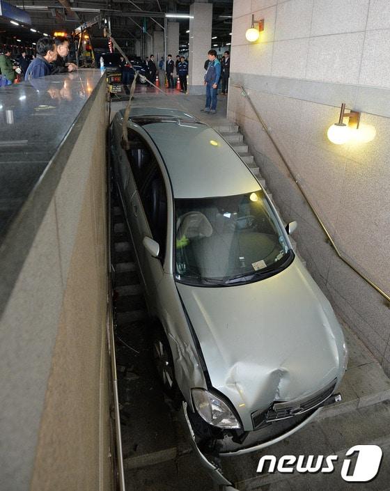 본문 이미지 - 30일 새벽 수원역사에서 버스승강장으로 통하는 계단에 승용차가 처박히는 사고가 일어났다. 이날 오전 수원역 관계자들이 사고차량을 견인하고 있다. 사고는 술을 마신 음주운전자가 인도용 계단을 주차장으로 착각해 일어났다. 인명피해는 없었다. 2014.11.30/뉴스1 ⓒ News1 김영진 기자