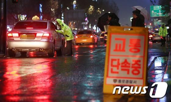 본문 이미지 - 서울경찰청 교통안전계 경찰관들이 지난해 12월 10일 밤 서울 종로 1가 대로변에서 택시 승차거부와 합승, 주ㆍ정차 위반 등 교통 무질서 행위 특별단속을 하고 있다.2014.12.11/뉴스1 / (서울=뉴스1) 오대일 기자 ⓒ News1