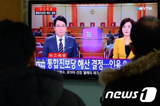 본문 이미지 - 헌법재판소가 통합진보당 해산 결정을 내린 19일 오후 서울 중구 회현동 서울역 대합실에서 시민들이 관련 뉴스를 시청하고 있다. 2014.12.19/뉴스1 ⓒ News1 정회성 기자