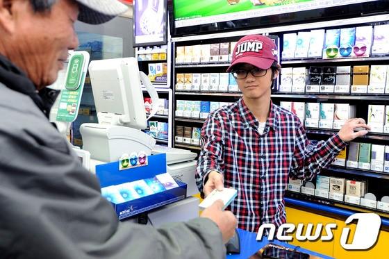 본문 이미지 - 한 편의점에서 점원이 손님에게 상품을 건네고 있다(사진은 기사 내용과 관련이 없음). 뉴스1 ⓒ News1