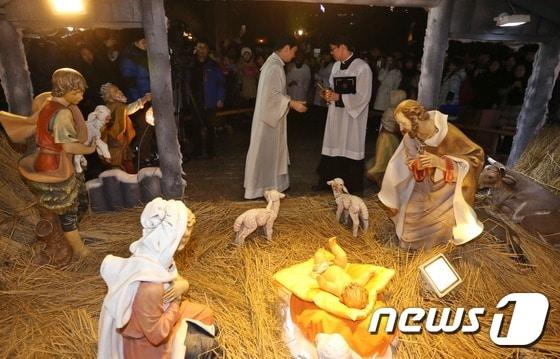 본문 이미지 - 크리스마스 이브인 24일 저녁 서울 중구 명동대성당에서 신부들이 아기 예수를 말구유에 안치하는 구유예절을 하고 있다. /뉴스1 ⓒ News1 송원영 기자