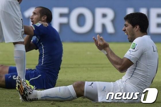 본문 이미지 - 수아레스(27)가 2014 브라질 월드컵 조별리그 이탈리아와의 경기에서 후반 34분 상대 수비수 조르조 키엘리니(30)의 어깨를 깨문 뒤 괴로워하는 행동을 취하고 있다. <a href="http://news1.kr/articles/2026576">ⓒ</a> AFP=News1