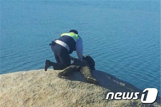 본문 이미지 - 9일 오후 1시27분께 신고를 받은 경찰관이 속초시 영랑호수로 기어들어가려던 자살기도자를 제지하는 모습.(사진제공=속초경찰서) 2014.12.9/뉴스1 2014.12.09/뉴스1 ⓒ News1 엄용주 기자