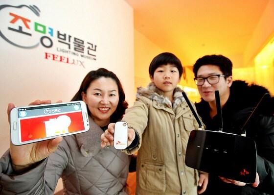 본문 이미지 - SK텔레콤의 초정밀 측위 기술인 'T 스마트 포지션'이 적용된 필룩스 조명 박물관 방문객들이 해당 서비스를 이용하면서 포즈를 취하고 있다..(사진제공=SK텔레콤)© News1  