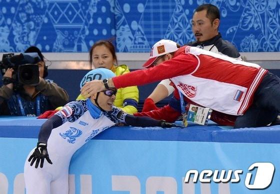 본문 이미지 - 러시아 쇼트 대표팀 안현수가 15일(한국시간) 러시아 소치 해안 클러스터 아이스버그 스케이팅 팔라스 경기장에서 열린 남자 개인 1,000m 결승 경기에서 1위로 결승선을 통과 후 코칭스텝의 축하를 받고 있다. 오른쪽 뒤의 남성은 한국 대표팀의 최광복 코치. 2014.2.15/뉴스1 © News1   (소치(러시아)=뉴스1) 이동원 기자