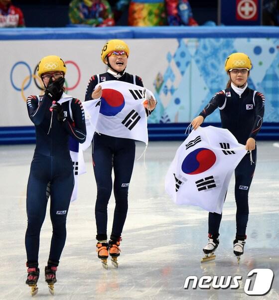 본문 이미지 - 대한민국 여자 쇼트트랙 계주 대표팀(심석희,박승희,김아랑,조해리,공상정)이 18일(한국시간) 러시아 소치 해안 클러스터 아이스버그 스케이팅 팔라스 경기장에서 열린 여자 계주 3,000m 결선 경기에서 1위로 결승선을 통과, 태극기를 들고 환호하고 있다.2014.2.18/뉴스1 © News1 (소치(러시아)=뉴스1) 이동원 기자