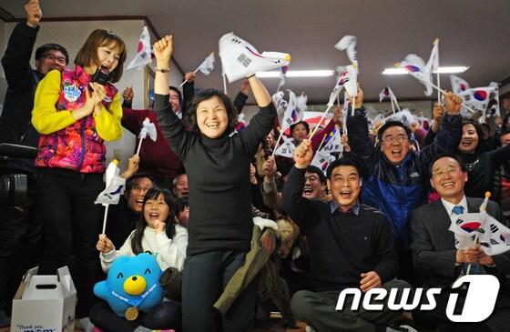 본문 이미지 - 18일 밤 전북 전주시 서서학동 주민센터에서 김아랑 선수 부모와 주민들이 2014 소치 동계올림픽 3000m 여자 계주 대표팀 선수들이 금메달을 확정 짓자 환호하고 있다.2014.2.18/뉴스1 © News1 김대웅 기자