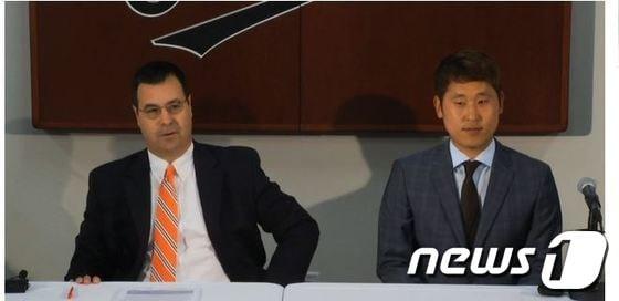 본문 이미지 - 볼티모어 오리올스 윤석민&#40;오른쪽&#41;과 댄 듀케 단장이 19일&#40;한국시간&#41; 미국 플로리다주 사라소타에 위치한 애드스미스 스타디움에서 입단식을 치르고 있다&#40;MLB 홈페이지 캡쳐&#41;.© News1  