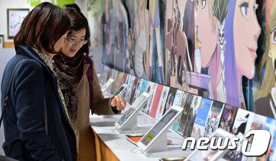 본문 이미지 - 2013 콘텐츠 창의인재 동반사업 성과발표회를 찾은 관람객들이 전시중인 창작만화를 감상하고 있다. © News1 박세연 기자