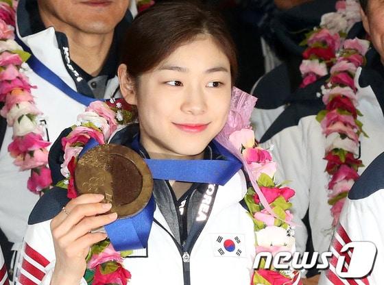 본문 이미지 - 2014 소치 동계올림픽 대표팀 김연아가 지난 2월 25일 인천국제공항 입국장을 통해 귀국하며 초콜릿으로 만든 &#39;국민행복 메달&#39;을 들어보이고 있다. /뉴스1 © News1 한재호 기자