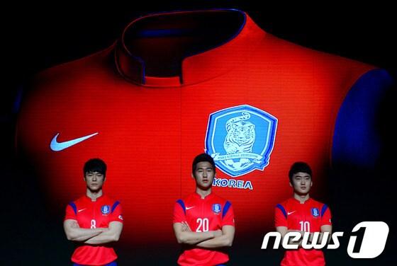 본문 이미지 - 27일 오전 서울 광화문 광장 세종대왕 동상 앞에서 2014 브라질 월드컵 대한민국 축구 국가대표팀 유니폼 발표회에서 U-20 대표팀 선수들이 유니폼을 입고 포즈를 취하고 있다. 대한축구협회와 나이키는 이날 발표한 홈 유니폼은 전통적으로 계승해 온 강렬한 붉은색 상의와 짙은 파란색 하의로 디자인되었으며, 빠른 스피드를 위한 '경량성'과 몸의 땀과 열을 컨트롤해 최상의 경기력을 유지할 수 있게 만든 '속건성'에 가장 중점을 둔 요소라고 밝혔다. 2014.2.27/뉴스1 © News1   박정호 기자