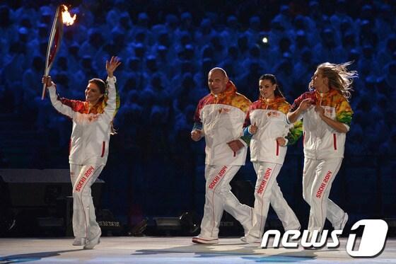 본문 이미지 - 블라디미르 푸틴 러시아 대통령과 한때 염문설이 있었던 리듬체조 스타 출신 알리나 카바예바가 8일 새벽&#40;한국시간&#41; 러시아 소치 피시티 올림픽 스타디움에서 열린 올림픽 개막식에서 성화를 봉송하고 있다.© AFP=News1 