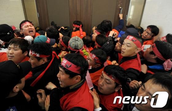 본문 이미지 - 폐광지역 개발지원에 관한 특별법 재정립 및 강원랜드 바로세우기 투쟁위원회(이하 투쟁위)가 21일 오후 강원도 정선군 강원랜드 컨벤션홀 입구에서 강원랜드 이사회를 저지하며 보안요원들과 몸싸움을 하고 있다. 2014.3.21/뉴스1 © News1 윤창완 기자