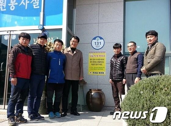 본문 이미지 - 곡성군 곡성읍사무소 앞에 놓여있는 나눔의 쌀 항아리 앞에서 곡성읍청년회원이 기념촬영을 갖고있다.2014.3.24/뉴스1(사진제공=곡성군) © News1 서순규 기자