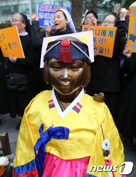 본문 이미지 - 지난달 26일 서울 중학동 일본대사관 앞에서 열린 1119차 일본군 '위안부' 문제 해결을 위한 정기 수요시위에서 소녀상 뒤에 자리한 수녀들이 일본 정부의 공식 사죄를 촉구하는 구호를 외치고 있다. 2014.3.26/뉴스1 © News1 오대일 기자