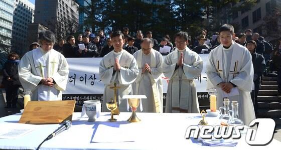 본문 이미지 - 지난달 서울 광화문 파이낸스빌딩 앞에서 열린 송파 세 모녀 자살 사건 추모의식에서 정의평화위원회 등 참석자들이 추모기도를 올리고 있다. © News1 양동욱 기자