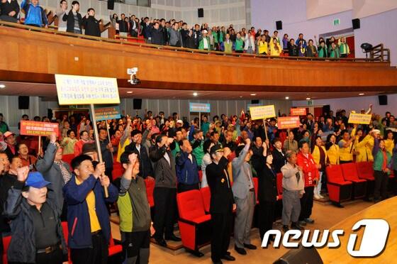 본문 이미지 - 14일 화천문화회관에서 동서고속화철도 화천역 설치를 위한 범 군민대책위원회가 출범했다. 출범위에 참석한 군민들이 피켓을 들고 화천역 설치를 위한 결의를 다지고 있다. © News1   홍성우 기자