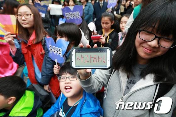 본문 이미지 - 위안부 문제 해결을 위한 한·일 양국의 첫 국장급 협의가 예정된 16일 서울 중학동 일본대사관 앞에서 열린 1122차 일본군 &#39;위안부&#39; 문제 해결을 위한 정기 수요시위에서 초등학생들이 일본 정부의 공식사죄를 촉구하는 문구를 스마트폰 액정에 적어보이고 있다.한국과 일본이 위안부 문제 해결을 단독 의제로 놓고 협의를 하는 것은 이번이 처음으로 아베 신조&#40;安倍晋三&#41; 일본 정부는 일본군 위안부 문제를 올해 말까지 타결하자는 입장을 한국 측에 전달한 것으로 알려졌다. 2014.4.16/뉴스1 © News1 오대일 기자