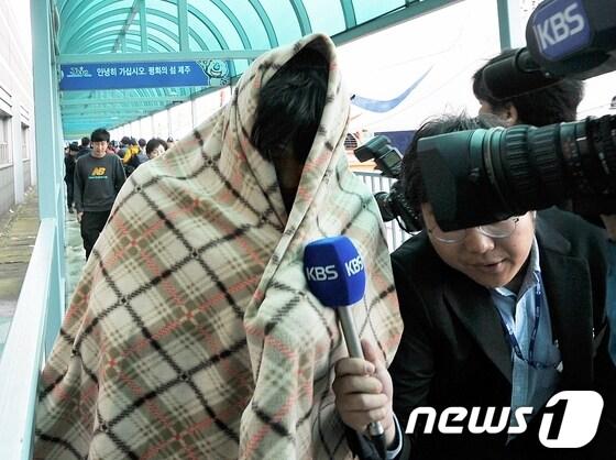 본문 이미지 - 침몰한 세월호에서 구조돼 17일 제주항에 도착한 한 제주 출신 승객이 모포를 뒤짚어 쓴채 급히 발걸음을 옮기고 있다.  © News1 이상민 기자  