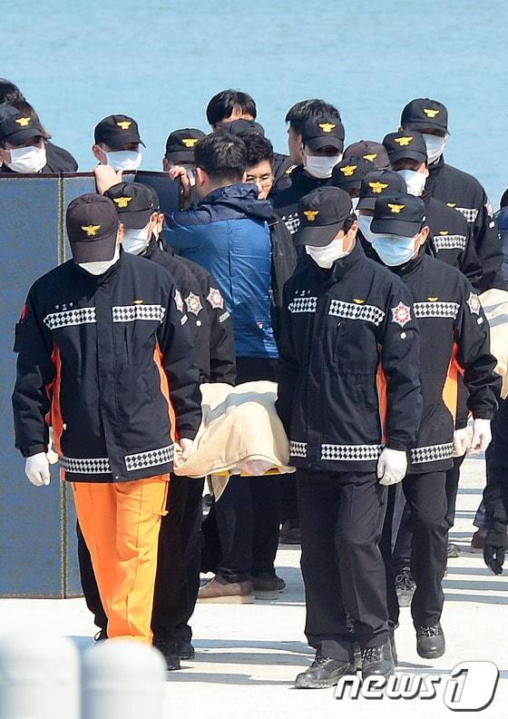 본문 이미지 - 전남 진도해상에서 발생한 세월호 침몰사고 닷새째인 20일 진도 팽목항 선착장에서 구조대가 시신을 옮기고 있다. 2014.4.20/뉴스1 © News1 장수영 기자