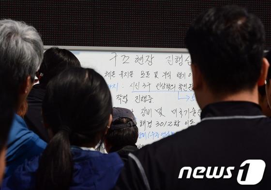 본문 이미지 - 전남 진도해상에서 발생한 세월호 침몰사고 닷새째인 20일 진도 팽목항에서 실종자 가족과 관계자들이 구조현장 진행상황판을 바라보고 있다. 2014.4.20/뉴스1 © News1 장수영 기자
