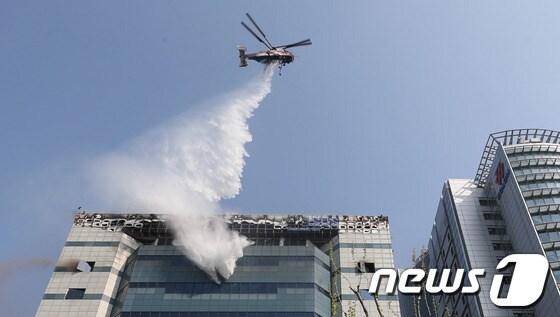 본문 이미지 - 20일 오후 12시 쯤 경기 과천시 삼성SDS 과천센터에서 불이나 소방대원들이 헬기와 소방차를 동원해 불을 진압하고 있다.이날 불은 과천 삼성SDS 건물 3층 발전기 실에서 발생해 외부로 번졌으며, 건물 내부에 있는 데이터 보관장비의 상당부분을 태우고 진화됐다. 특히 소방당국이 진화를 위해 뿌린 물로 삼성SDS 대규모 장비가 침수돼 고장이 났다. 소방당국은 경찰,시청 등 인원 67명과 소방헬기 등 장비 28대를 동원해 긴급진화에 나섰다. 삼성SDS측은 “과천센터는 백업데이터를 보관하는 곳으로 메인센터는 수원에 있다”며“데이터 유실은 없는 것으로 보인다”고 말했다.2014.4.20/뉴스1  © News1   송원영 기자