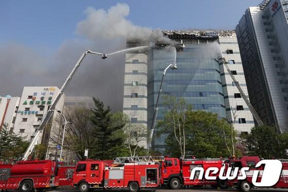 본문 이미지 - 20일 오후 12시 쯤 경기 과천시 삼성 SDS 과천센터에서 불이나 소방대원들이 화재를 진압하고 있다.이날 불은 과천 삼성SDS 건물 3층 발전기 실에서 발생해 외부로 번졌으며, 건물 내부에 있는 데이터 보관장비의 상당부분이 불에 탔다. 특히 소방당국이 진화를 위해 뿌린 물로 삼성SDS 대규모 장비가 침수돼 고장이 났다. 소방당국은 경찰,시청 등 인원 67명과 소방헬기 등 장비 28대를 동원해 긴급진화에 나섰다. 삼성SDS측은 “과천센터는 백업데이터를 보관하는 곳으로 메인센터는 수원에 있다”며“데이터 유실은 없는 것으로 보인다”고 말했다.2014.4.20/뉴스1  © News1   송원영 기자