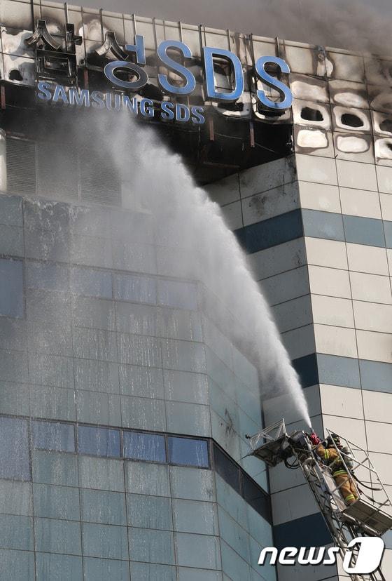 본문 이미지 - 20일 오후 12시 쯤 경기 과천시 삼성 SDS 과천센터에서 불이나 소방대원들이 화재를 진압하고 있다.이날 불은 과천 삼성SDS 건물 3층 발전기 실에서 발생해 외부로 번졌으며, 건물 내부에 있는 데이터 보관장비의 상당부분이 불에 탔다. 특히 소방당국이 진화를 위해 뿌린 물로 삼성SDS 대규모 장비가 침수돼 고장이 났다. 소방당국은 경찰,시청 등 인원 67명과 소방헬기 등 장비 28대를 동원해 긴급진화에 나섰다. 삼성SDS측은 “과천센터는 백업데이터를 보관하는 곳으로 메인센터는 수원에 있다”며“데이터 유실은 없는 것으로 보인다”고 말했다.2014.4.20/뉴스1  © News1   송원영 기자