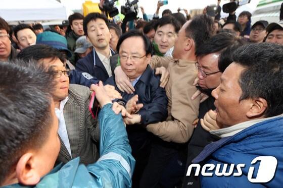 본문 이미지 - 세월호 여객선 침몰 사고 발생 닷새째인 20일 오후 전남 진도 팽목항 상황본부를 찾은 이주영 해양수산부 장관이 실종자 가족들의 항의를 받으며 해경 관계자와 취재진에 둘러싸여 있다. © News1 한재호 기자