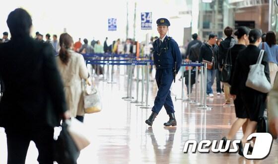 본문 이미지 - 공항 경찰이 20일 일본 하네다 공항을 순찰하고 있다. © AFP=뉴스1 