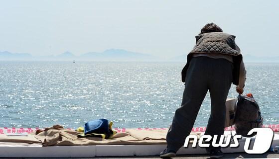 본문 이미지 - 세월호 여객선 침몰 사고 발생 8일째인 23일 전남 진도 팽목항에 희생자 추모와 실종자들의 무사생환 기도를 마친 한 불교 신자가 떠나기 위해 짐을 싸고 있다. 2014.4.23/뉴스1 © News1 양동욱 기자