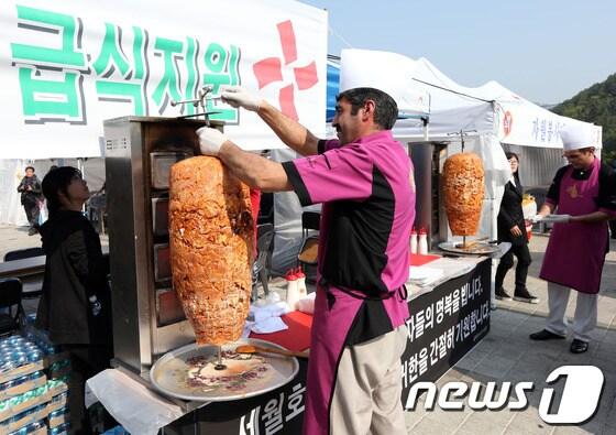 본문 이미지 - 세월호 여객선 침몰 사고 발생 9일째인 24일 전남 진도군 진도실내체육관 앞에서 급식 자원봉사에 나선 주한 터키인들이 케밥을 조리하고 있다. 2014.4.24/뉴스1 © News1   한재호 기자