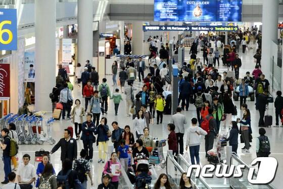 본문 이미지 - 5월 1일 근로자의 날을 시작으로 석가탄신일인 6일까지 이어지는 황금연휴를 앞둔 30일 인천국제공항 면세점이 출국하는 여행객들로 붐비고 있다. 2014.4.30/뉴스1 © News1   안은나 기자