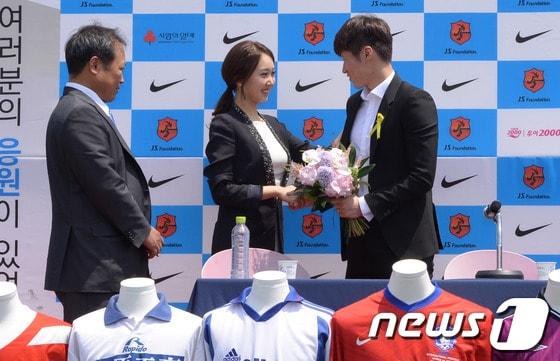 본문 이미지 - 은퇴를 선언한 박지성&#40;오른쪽&#41;이 14일 오전 경기도 수원시 영통구 박지성축구센터에서 열린 은퇴기자회견에서 깜짝 방문한 예비신부 김민지&#40;전 아나운서&#41;씨의 꽃다발을 받고 있다.2014.5.14/뉴스1 © News1   이동원 기자